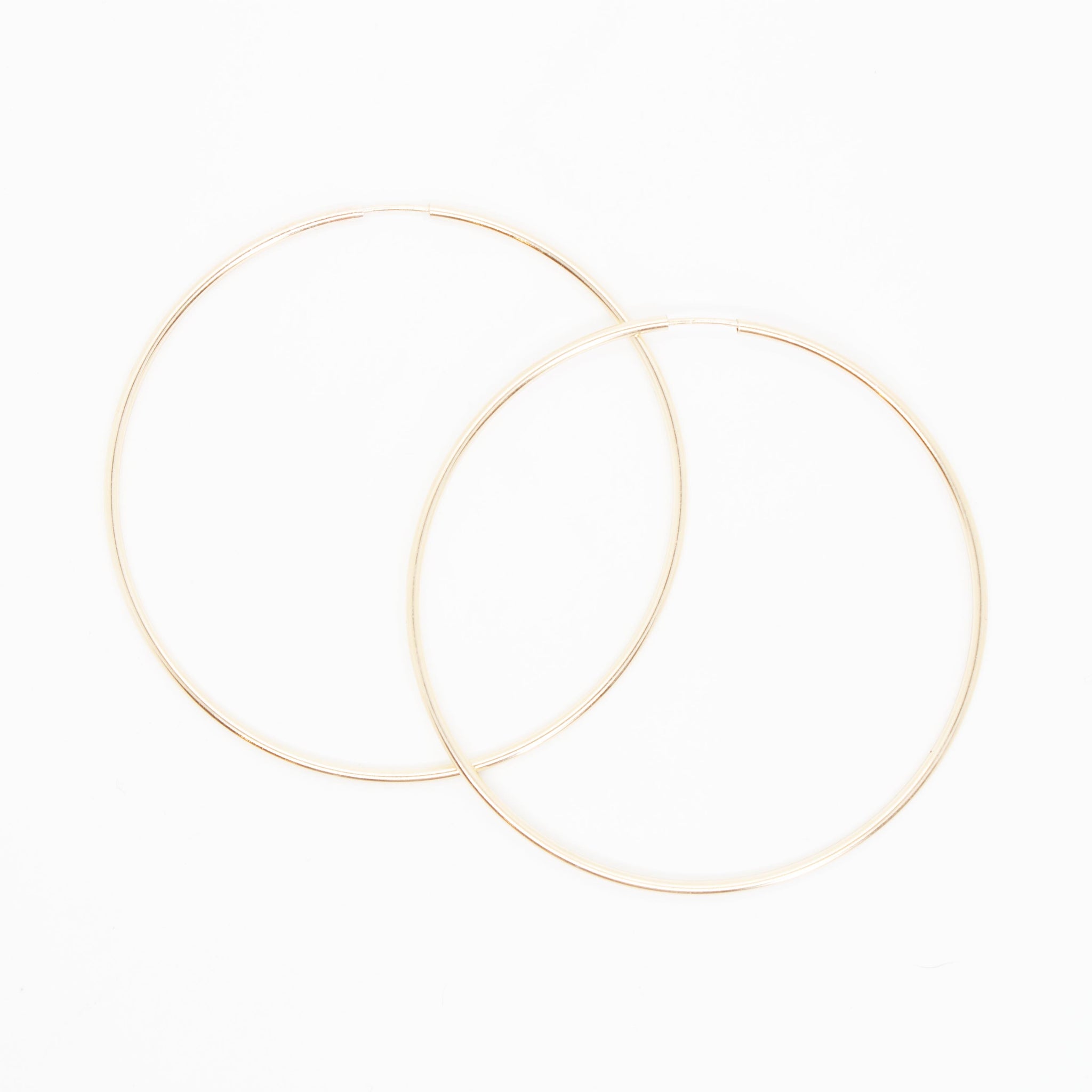 Make a statement with these substantial yet delicate gold hoops. 14 kt gold filled* endless hoop earrings 50mm diameter. *Gold-filled jewelry is composed of a solid layer of gold, mechanically bonded to sterling silver. You are fine to shower in it, get it wet, wear it for life! kp jewelry co.