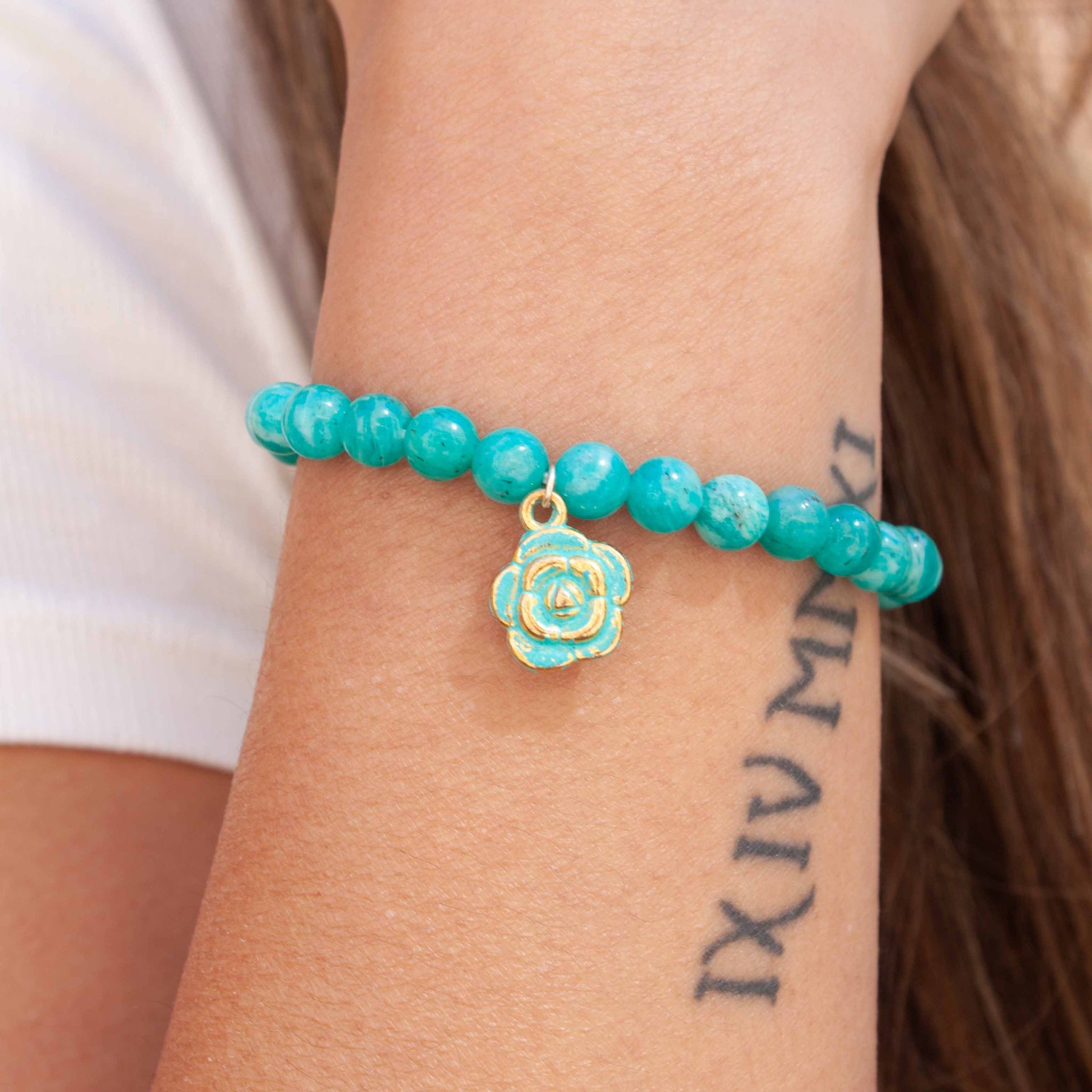 Savour the soothing aqua-green of these Russian amazonite beads and their sweet blue dahlia charm. Punch it up with our 14 karat gold filled bracelet! 7" russian amazonite bracelet and gold plated dahlia charm, 14 kt gold filled stacking bracelet double strung with silk elastic. Handmade in Toronto by kp jewelry co. 