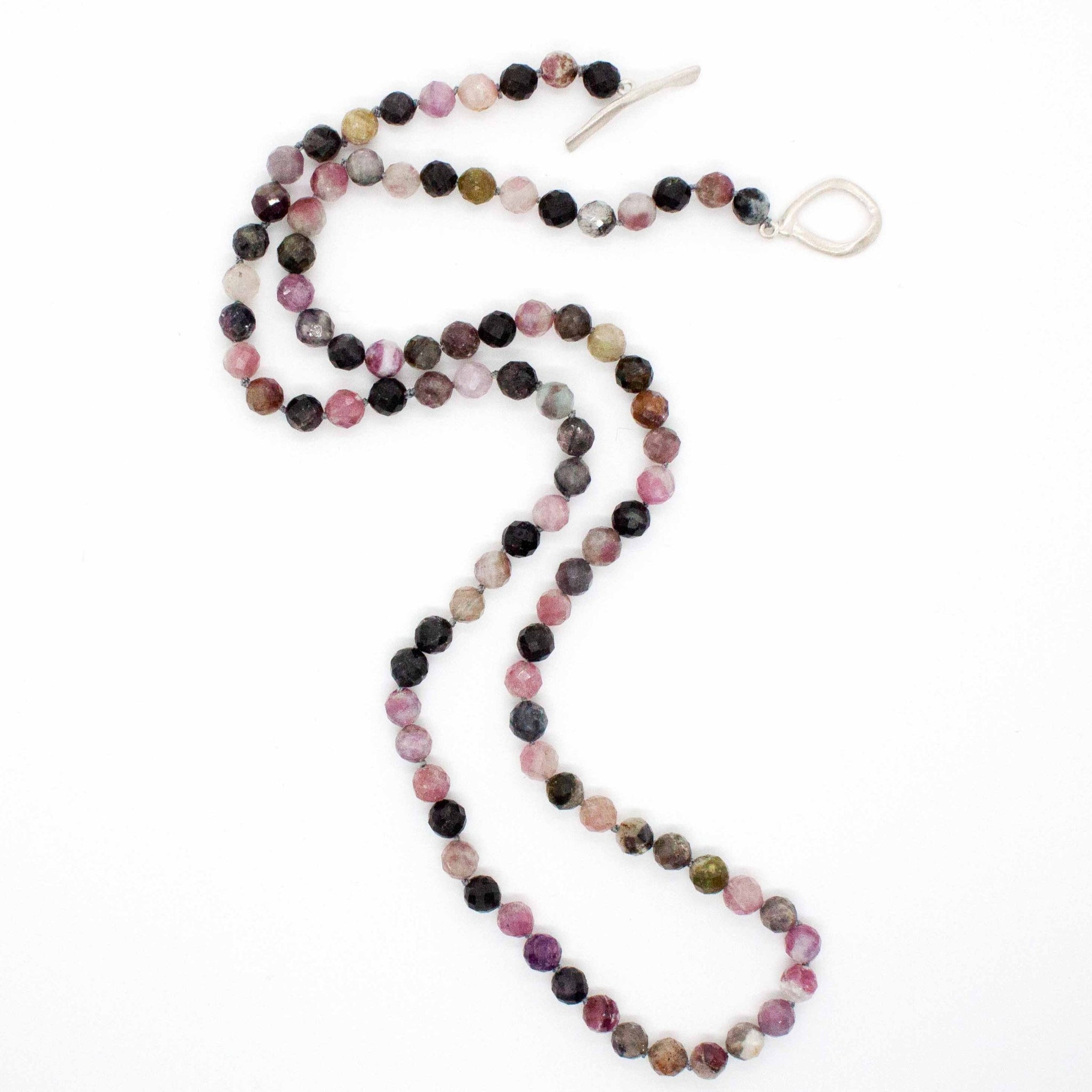 A colourful, one-of-a-kind necklace that sits at the perfect length for t-shirts, v-necks or open-neck blouses. For any season, this rainbow tourmaline necklace is an eye-catching addition piece that you'll wear again and again. one-of-a-kind 26" hand knotted rainbow tourmaline necklace with brushed sterling silver toggle clasp. Handmade in Toronto by kp jewelry co.