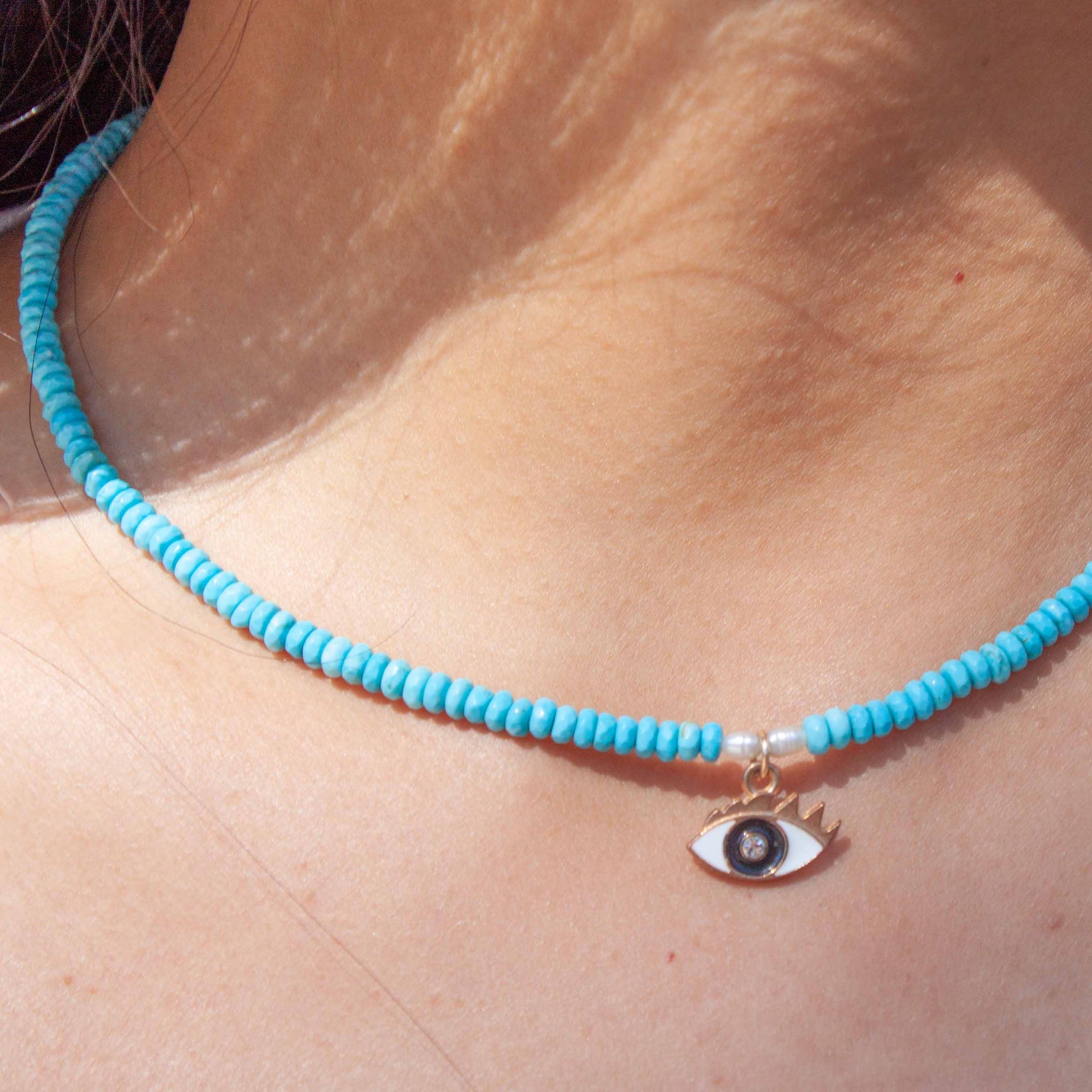 A universal symbol of protection, the evil eye talisman dates back to ancient Greece. This charm is paired with bright turquoise beads and freshwater pearls. 16" necklace beaded with synthetic, faceted turquoise beads and freshwater pearls enamel evil eye pendant with sparkly iris. Made in Toronto by kp jewelry co.